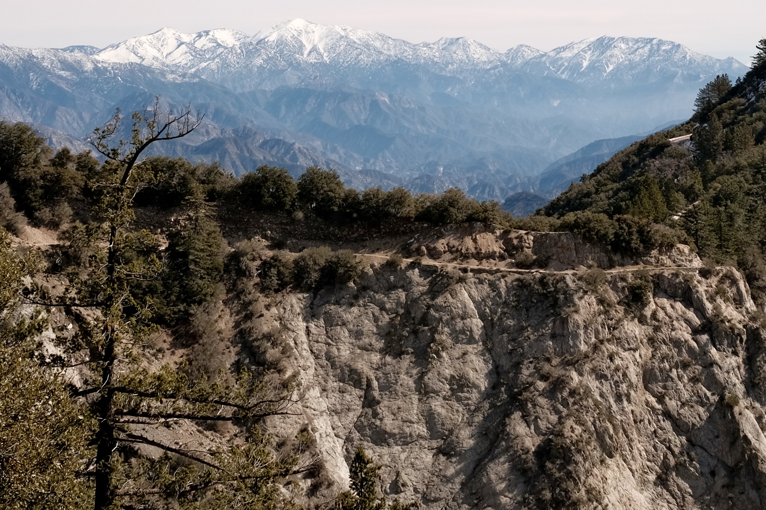 White capped mountains in the background with a rocky trail nearby 