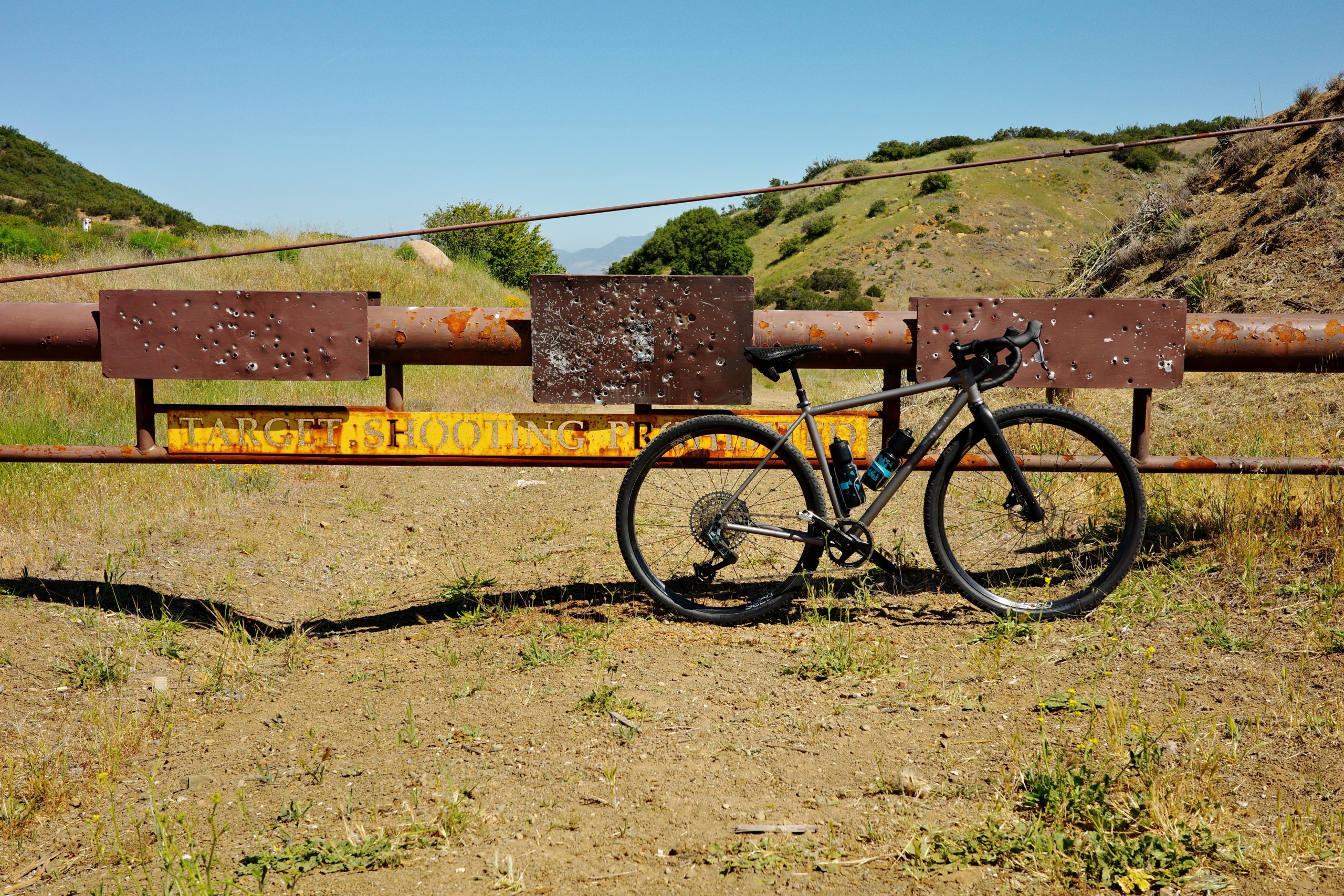 Bike leaning against gate that says “target shooting prohibited”